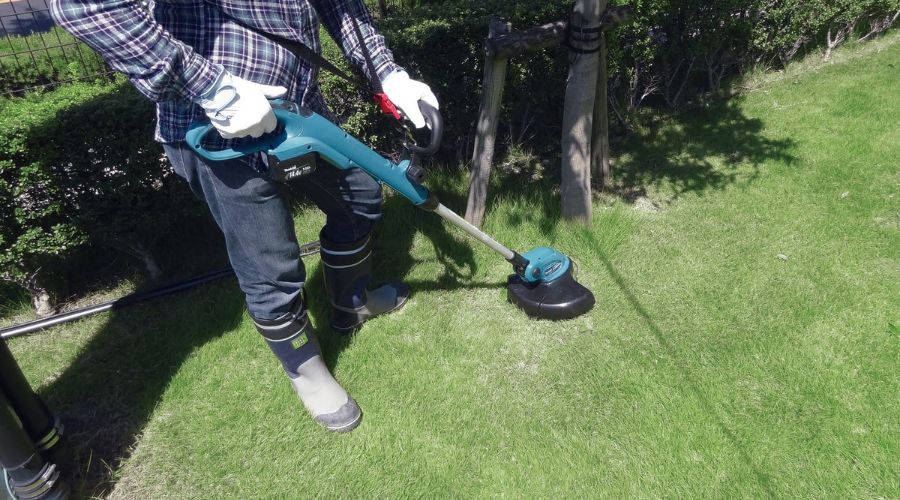 A picture showing a man using Makita XRU02Z 18V LXT Lithium-Ion Cordless String Trimmer, one of the best cordless string trimmer to cut grass on his lawn