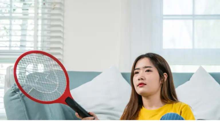 An image showing an image of a woman using bug zapper to kill mosquitos